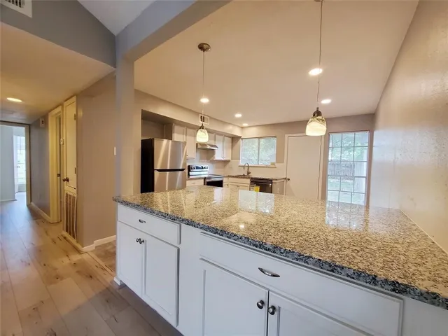 a kitchen with stainless steel appliances granite countertop a sink and a counter top space