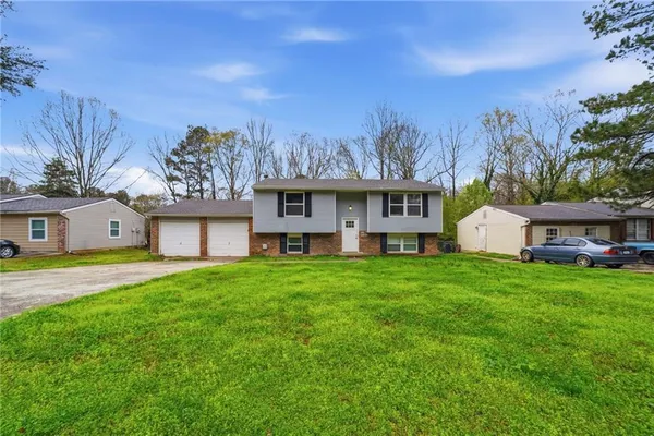 a view of a house with a big yard plants and large trees