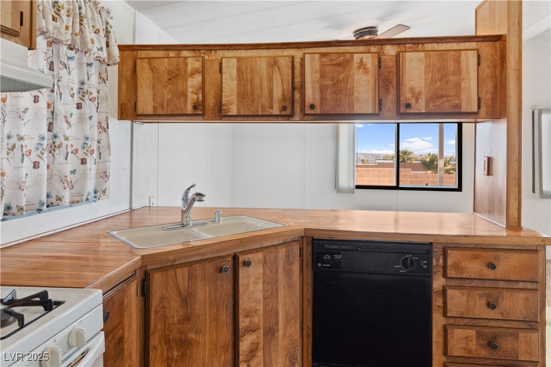 1671 Granada Street Laughlin, NV 89029 - Photo 13 of 63 Kitchen featuring a sink, brown cabinetry, dishwasher, and light countertops