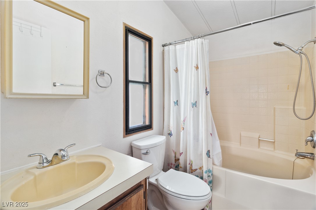 1671 Granada Street Laughlin, NV 89029 - Photo 24 of 63 Full bathroom featuring shower / tub combo with curtain, vanity, and toilet