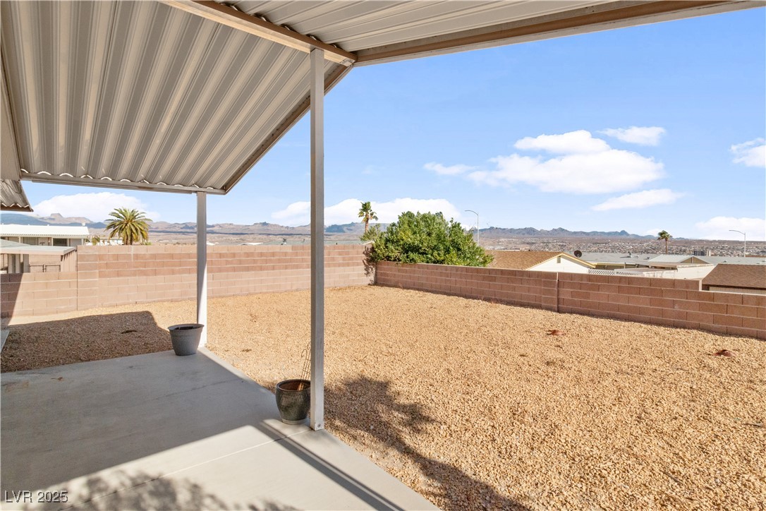 1671 Granada Street Laughlin, NV 89029 - Photo 42 of 63 View of yard with a fenced backyard, a patio, and a mountain view