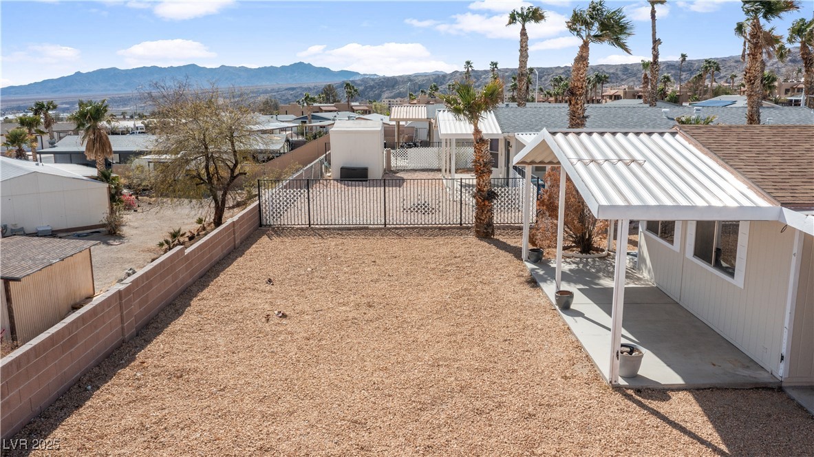 1671 Granada Street Laughlin, NV 89029 - Photo 54 of 63 View of yard with a residential view, a patio area, a fenced backyard, and a mountain view