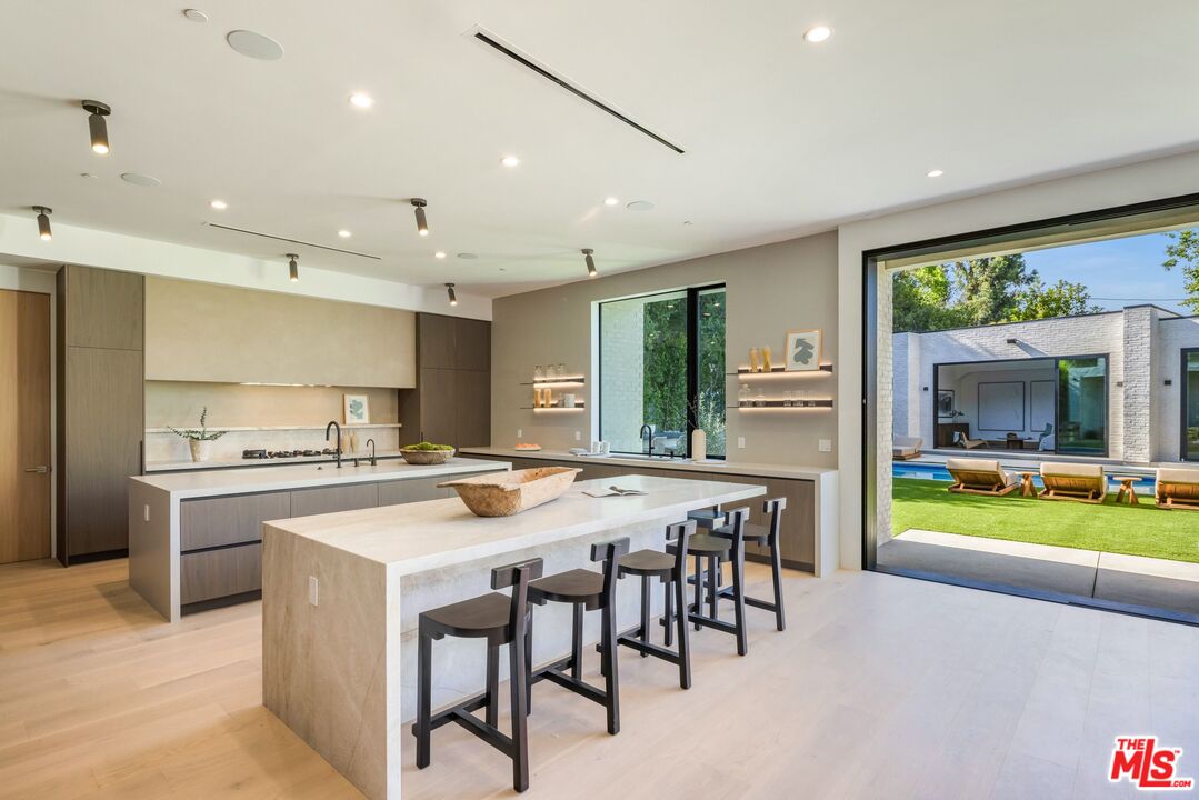 17055 Rancho Street Encino, CA 91316 - Photo 35 of 73 a kitchen with a table and chairs
