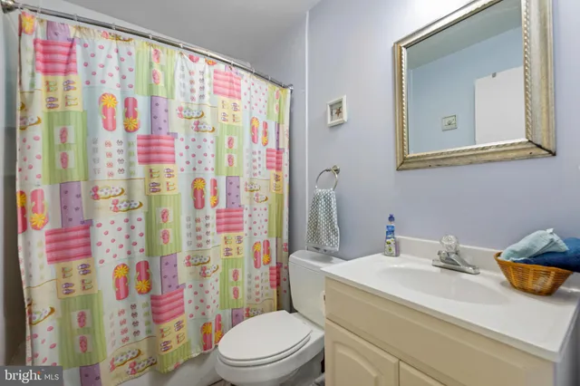 a bathroom with a sink toilet and shower curtain