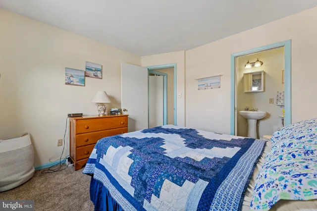 a bedroom with a bed and a lamp on dresser