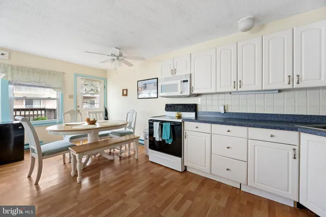 a kitchen with stainless steel appliances white cabinets and wooden floor