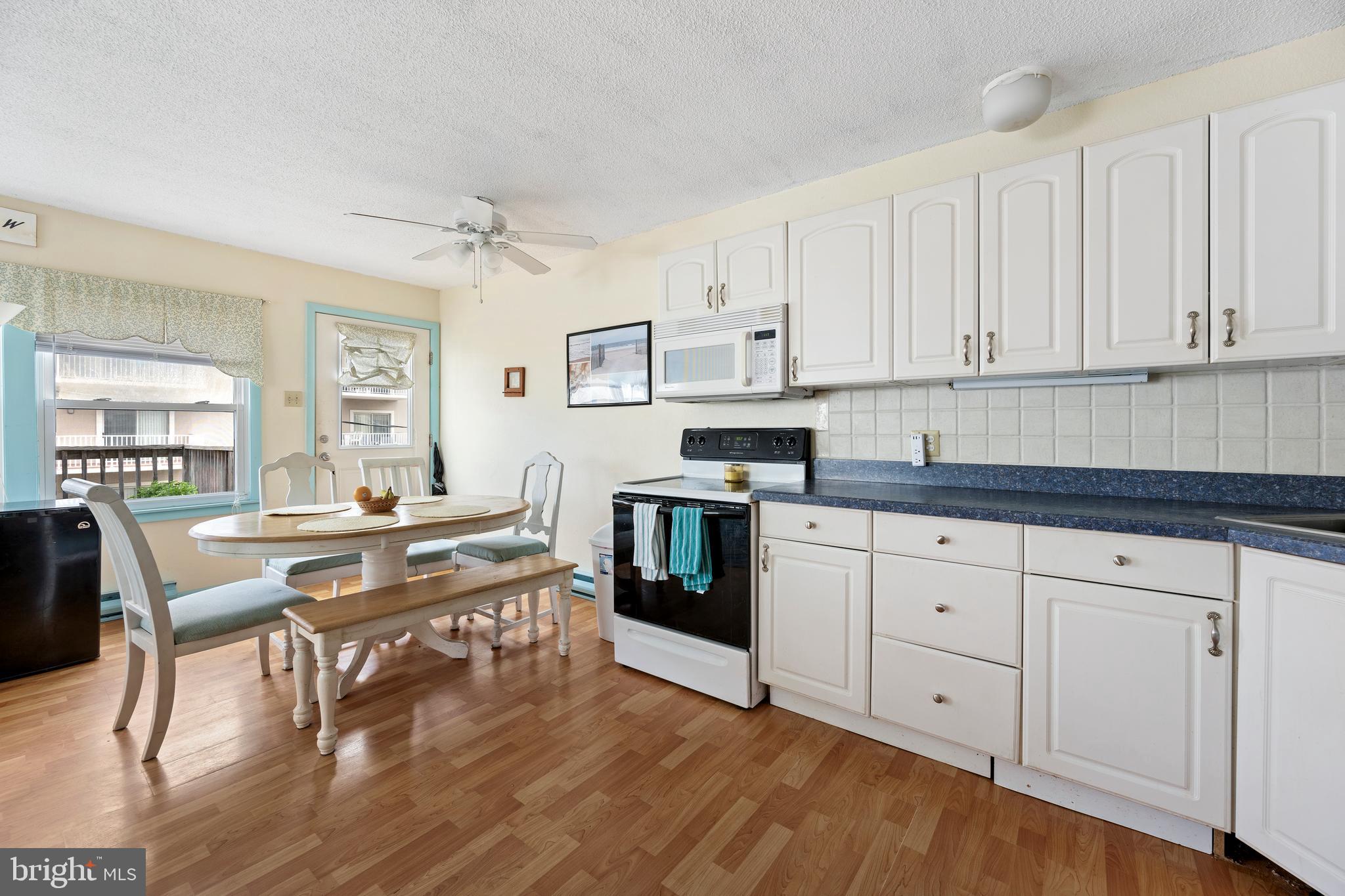 9 79th Street, Unit 3W Ocean City, MD 21842 - Photo 9 of 34 a kitchen with stainless steel appliances white cabinets and wooden floor