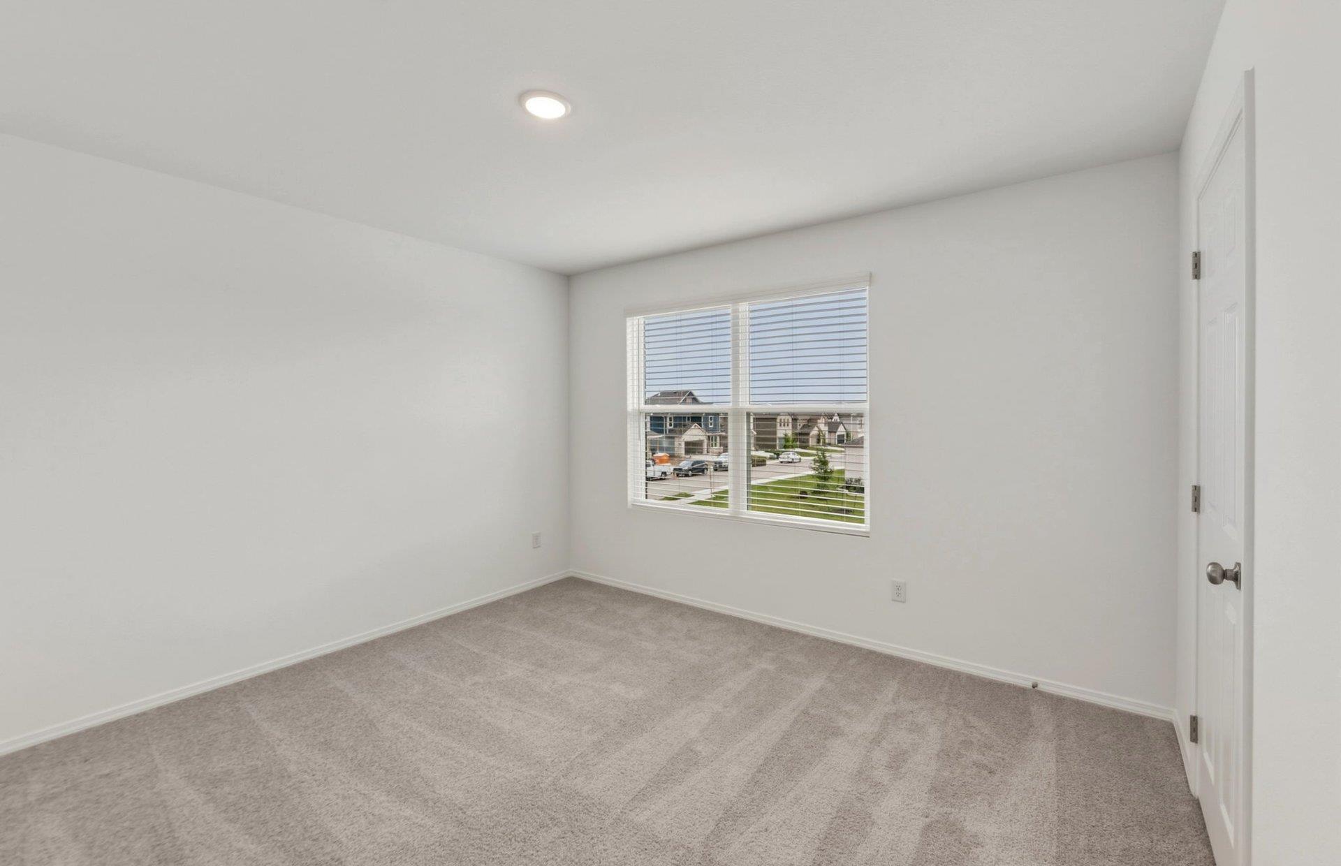 545 Henry Milton Road Georgetown, TX 78626 - Photo 23 of 33 A spacious secondary bedroom features plush carpeting and a large window overlooking the neighborhood.