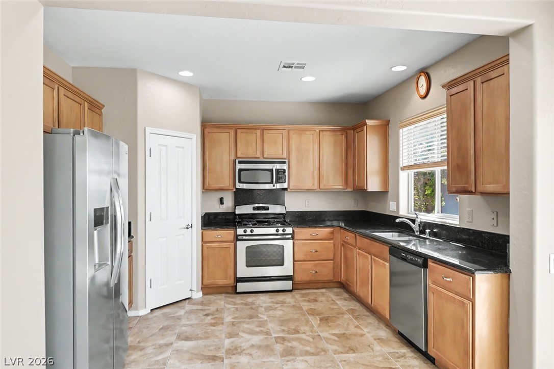 2356 Rue Bienville Way Henderson, NV 89044 - Photo 7 of 20 This spacious kitchen offers ample cabinet storage and stainless steel appliances, creating a functional culinary space.
