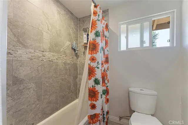 a bathroom with a toilet and a shower curtain