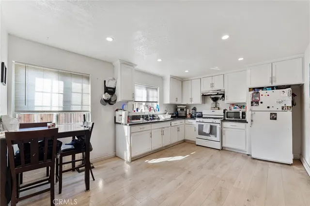 a kitchen with white cabinets and white appliances