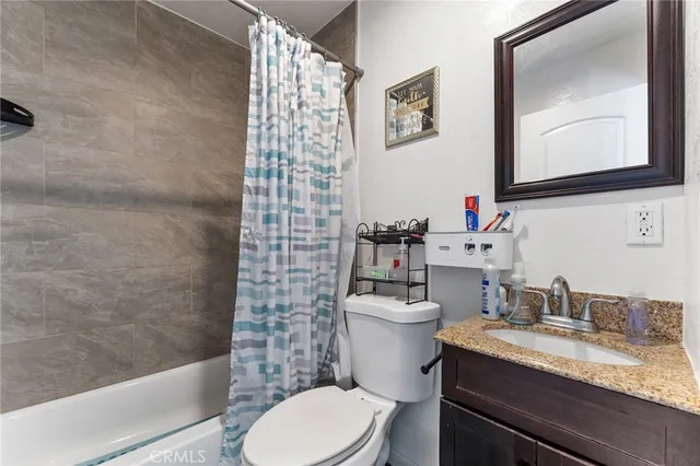 a bathroom with a granite countertop toilet sink and mirror
