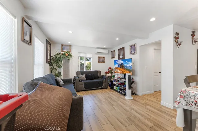 a living room with furniture or wooden floor and a flat screen tv