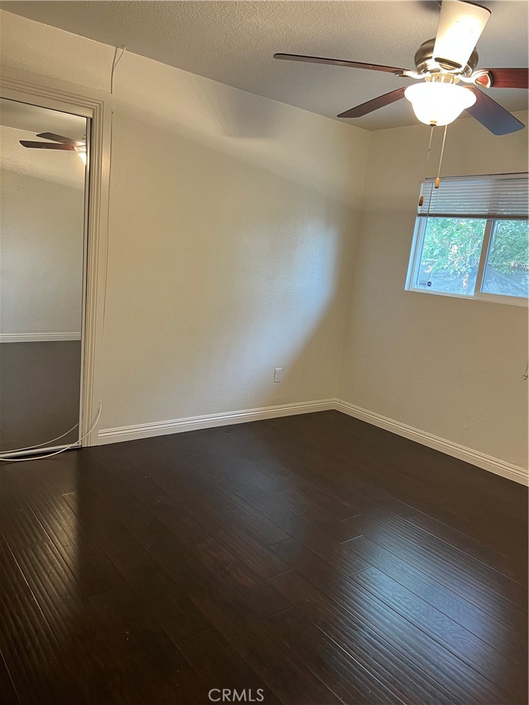 9127 Greenleaf Avenue Whittier, CA 90602 - Photo 7 of 39 an empty room with wooden floor chandelier fan and windows