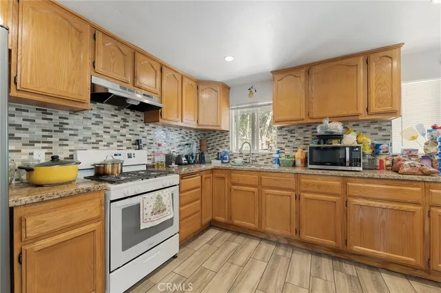 a kitchen with stainless steel appliances granite countertop a sink stove and cabinets
