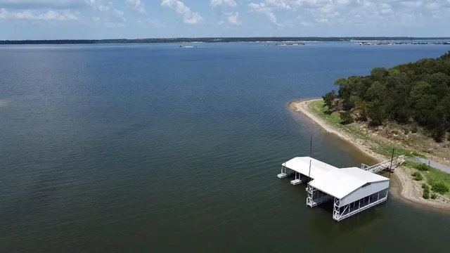 a white bath tub sitting in a shelf next to a lake