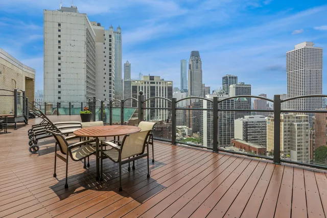 a roof deck with chairs and wooden floor
