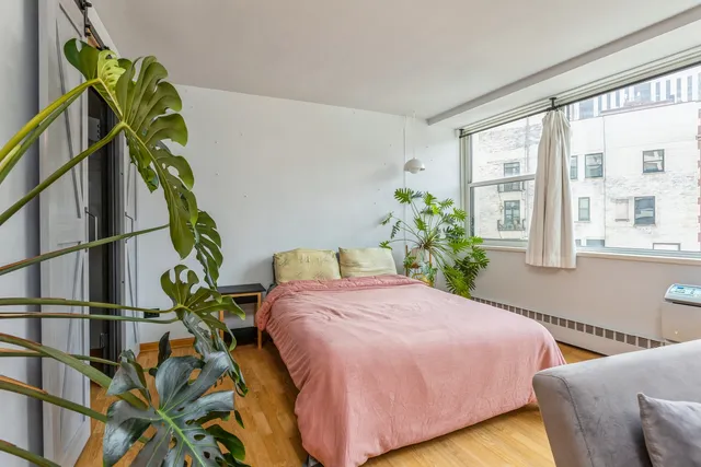 a bedroom with a bed table and a window