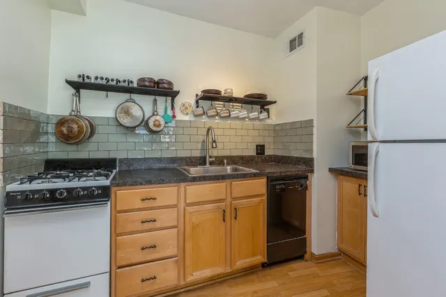 a kitchen with stainless steel appliances granite countertop a stove and a refrigerator