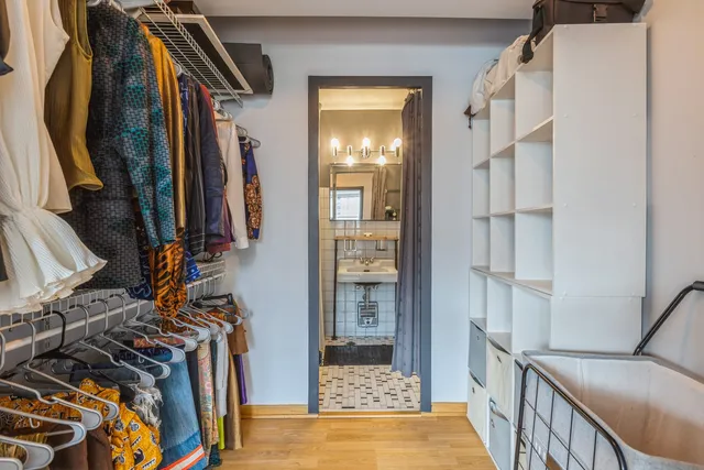 a view of walk in closet with clothes and shoes