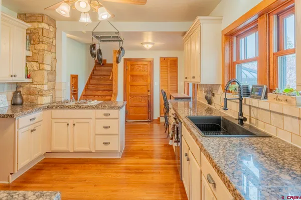 a kitchen with granite countertop a sink and a stove