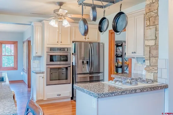 a kitchen with stainless steel appliances granite countertop a sink a stove and refrigerator