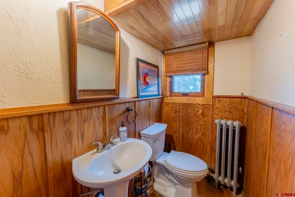 a bathroom with a sink a toilet and mirror