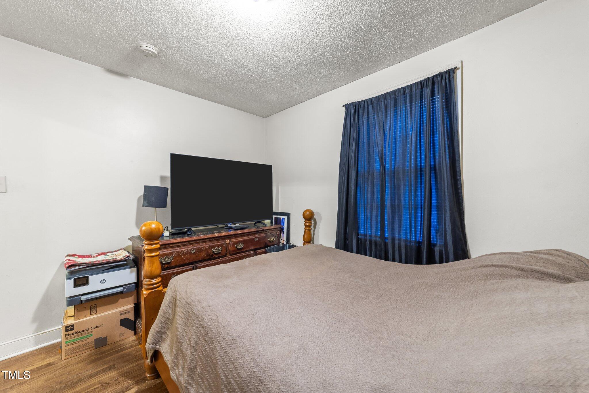 313 Colleton Road Raleigh, NC 27610 - Photo 15 of 32 a bedroom with a bed and a flat screen tv