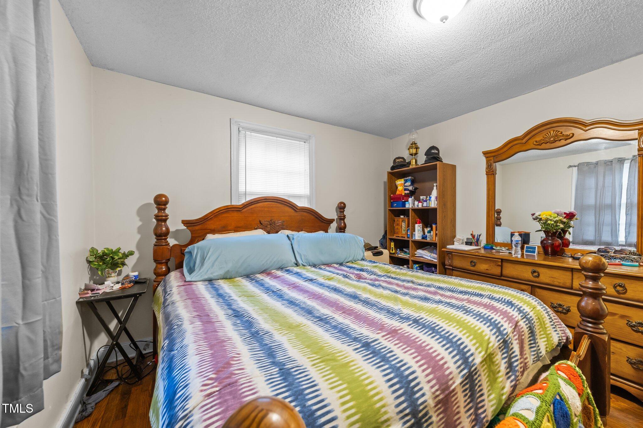 313 Colleton Road Raleigh, NC 27610 - Photo 9 of 32 a bedroom with bed and a chandelier