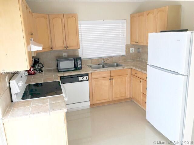11447 Southwest 33rd Lane Miami, FL 33165 - Photo 5 of 8 a kitchen with a sink a refrigerator and window