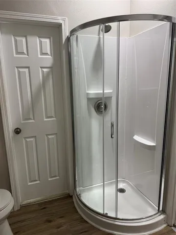 a bathroom with a granite countertop shower a toilet and a sink