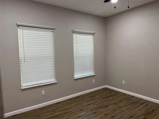 a room with wooden floor and windows