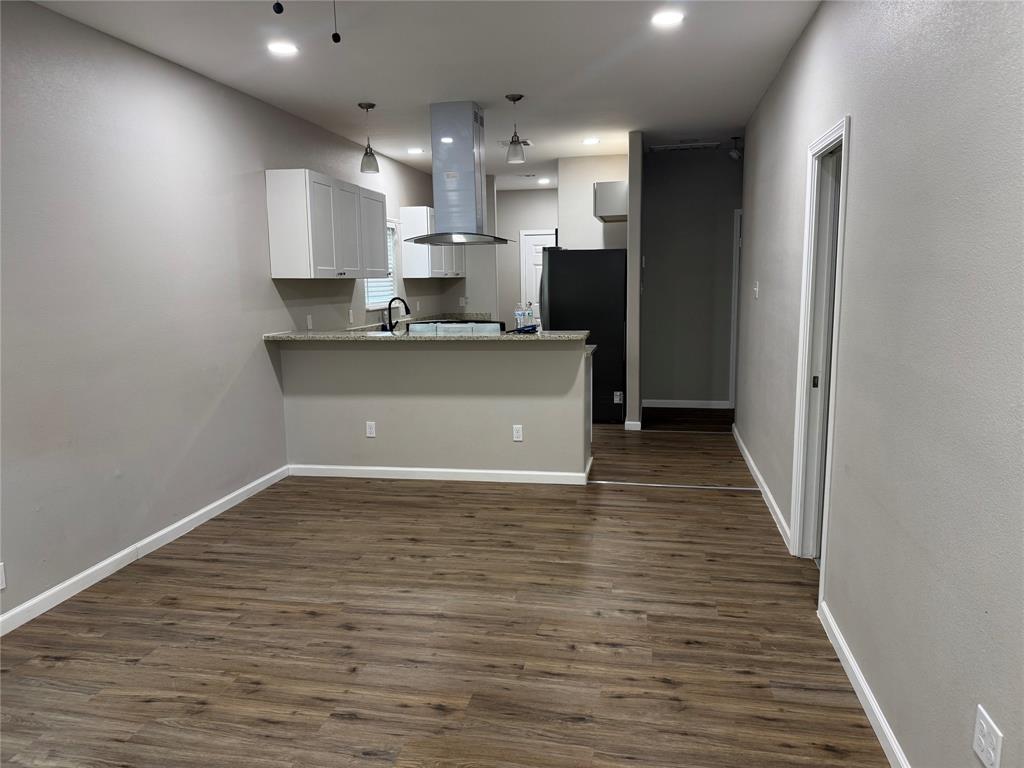 211 North Bermuda Street Lacy-Lakeview, TX 76705 - Photo 5 of 23 a large white kitchen with kitchen island a sink wooden floor and stainless steel appliances