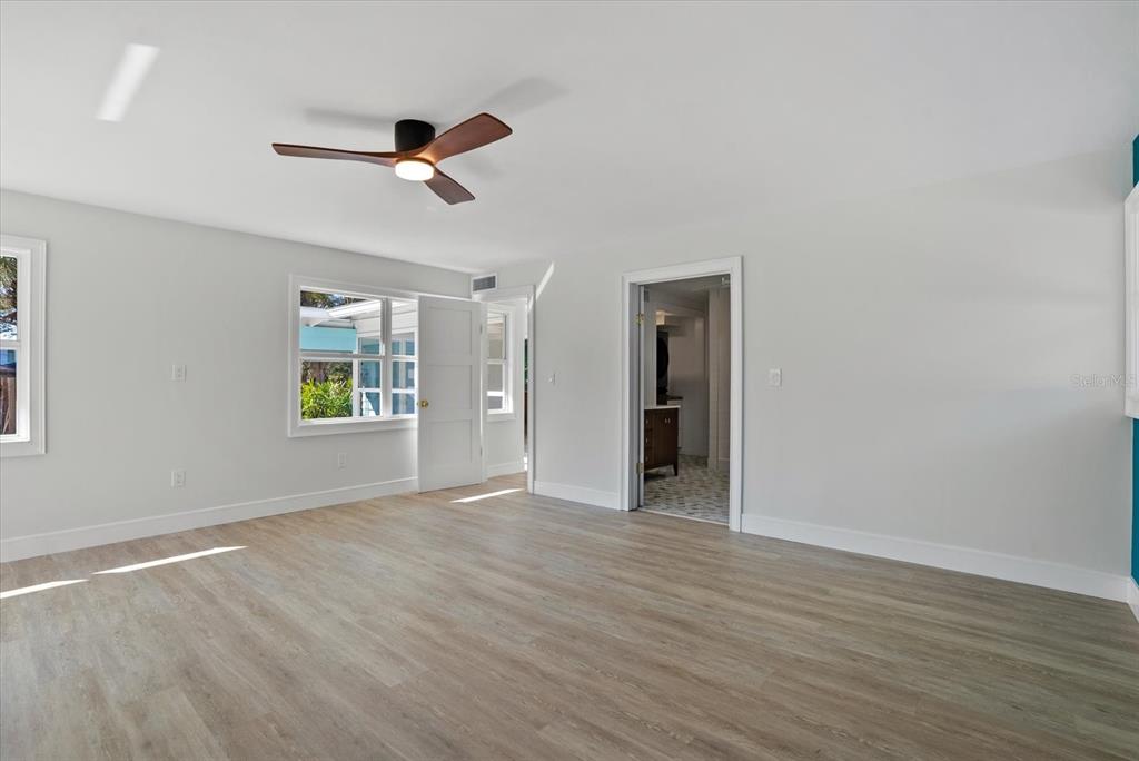 2104 Datura Street Sarasota, FL 34239 - Photo 18 of 48 a view of an empty room with wooden floor and a window