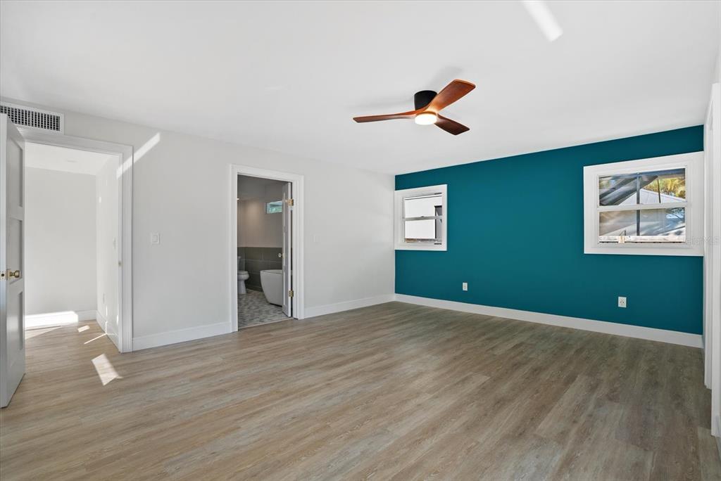 2104 Datura Street Sarasota, FL 34239 - Photo 19 of 48 a view of an empty room with wooden floor and a ceiling fan