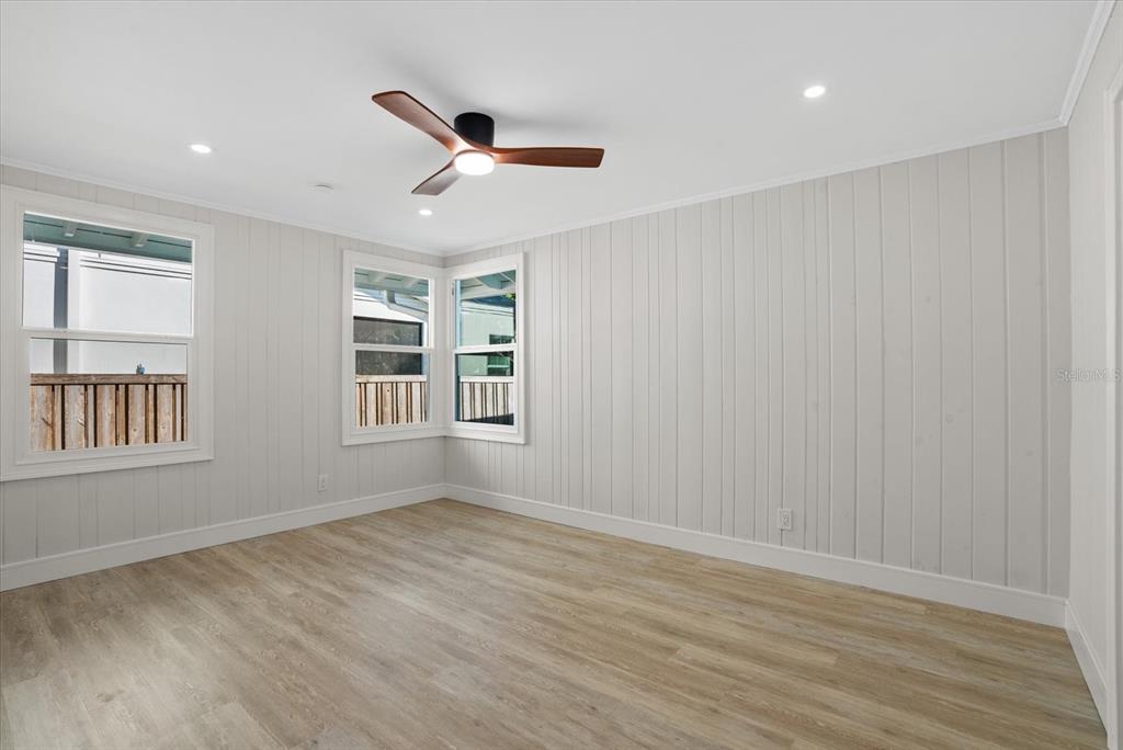 2104 Datura Street Sarasota, FL 34239 - Photo 26 of 48 an empty room with wooden floor fan and windows