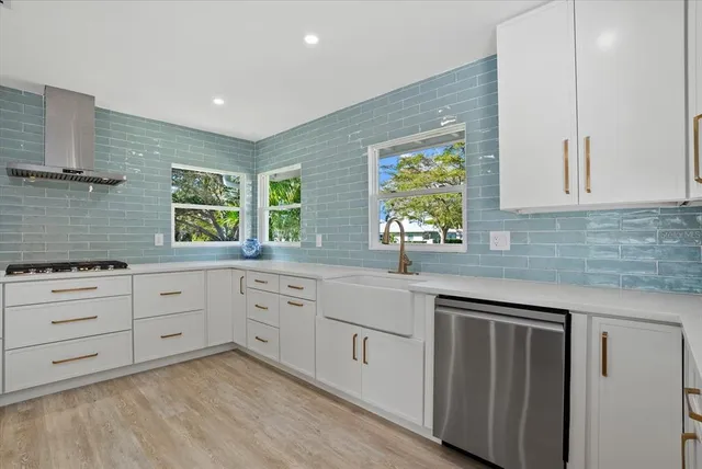 a kitchen with white cabinets and window