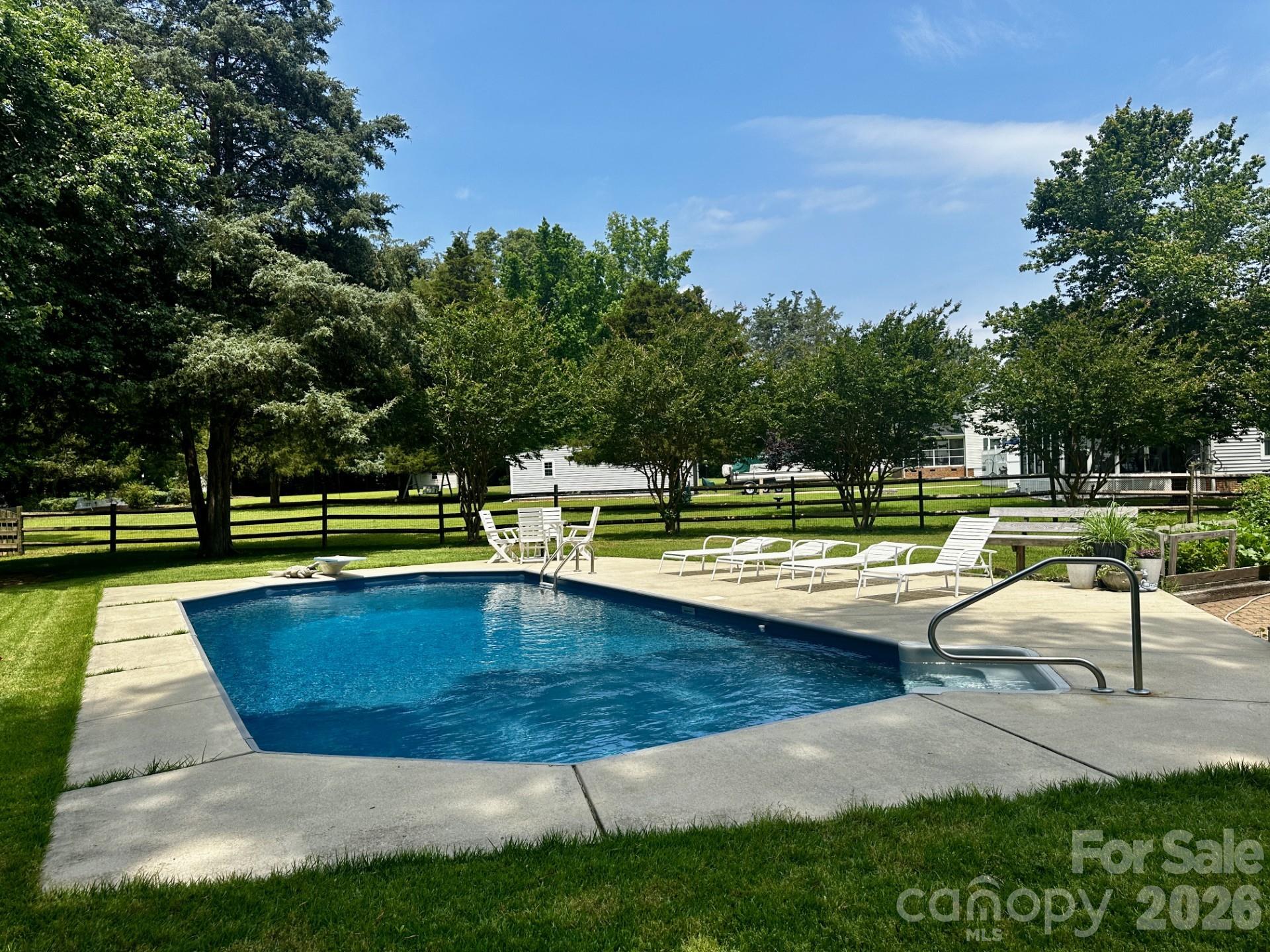 2915 Timber Ridge Lane Rock Hill, SC 29732 - Photo 32 of 41 a view of a swimming pool with a chair and trees in the background