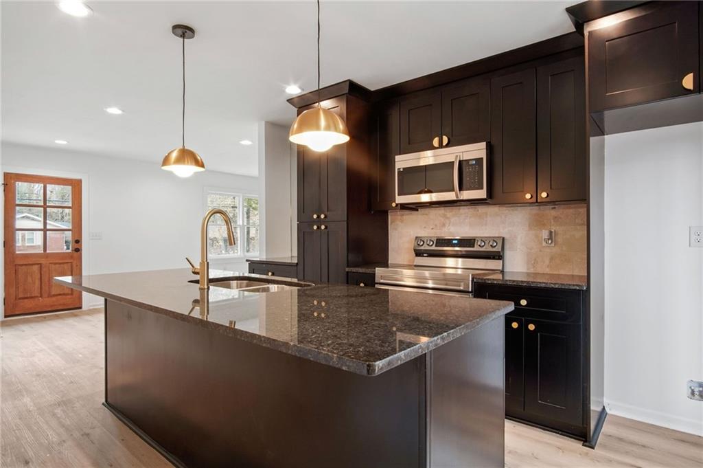2327 El Paso Road Southwest Atlanta, GA 30331 - Photo 10 of 35 a kitchen with stainless steel appliances granite countertop a sink a microwave and wooden floors