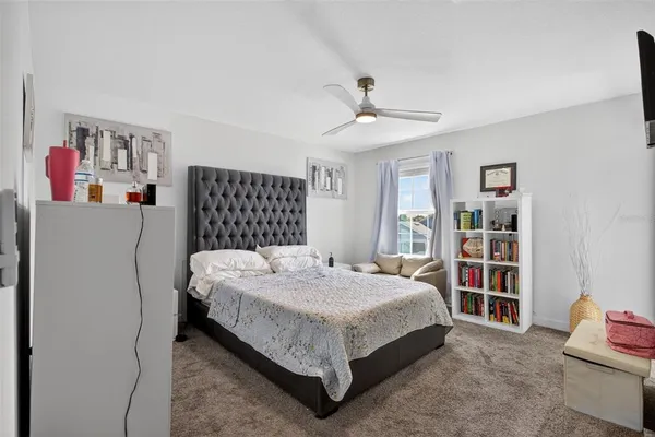 a bed sitting in a bedroom next to a book shelf