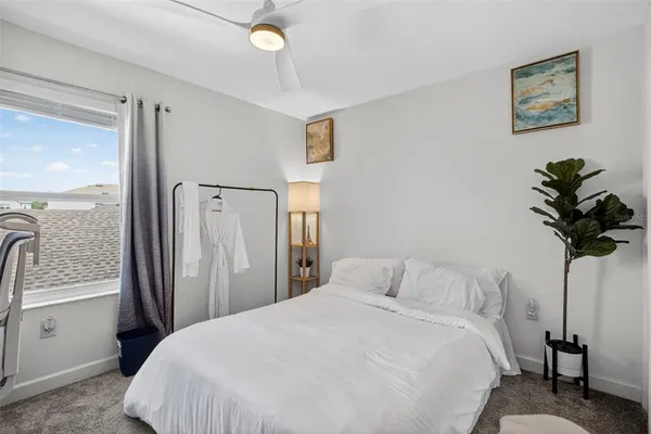 a bedroom with a bed and a potted plant