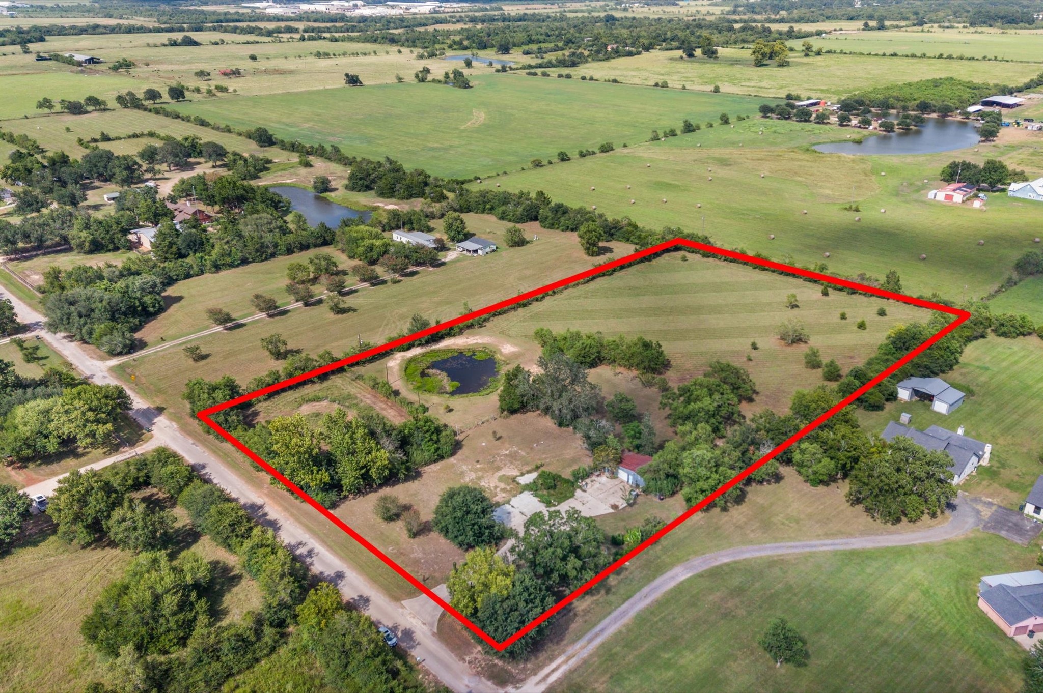 Fully outlined 5-acre perimeter showing site layout, open pasture, and natural tree coverage.