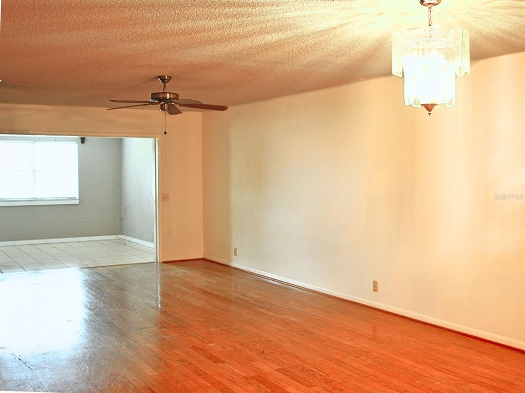2282 Firestone Place Winter Haven, FL 33884 - Photo 13 of 34 a view of a room with wooden floor and a ceiling fan