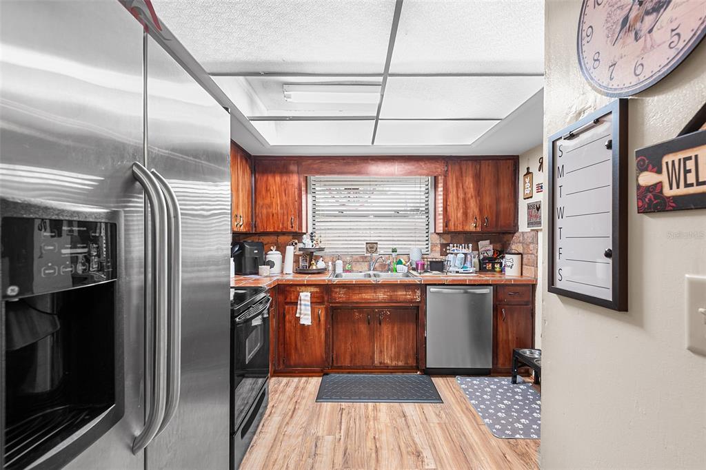 2282 Firestone Place Winter Haven, FL 33884 - Photo 7 of 34 a kitchen with stainless steel appliances granite countertop a refrigerator a sink dishwasher a stove and white cabinets with wooden floor