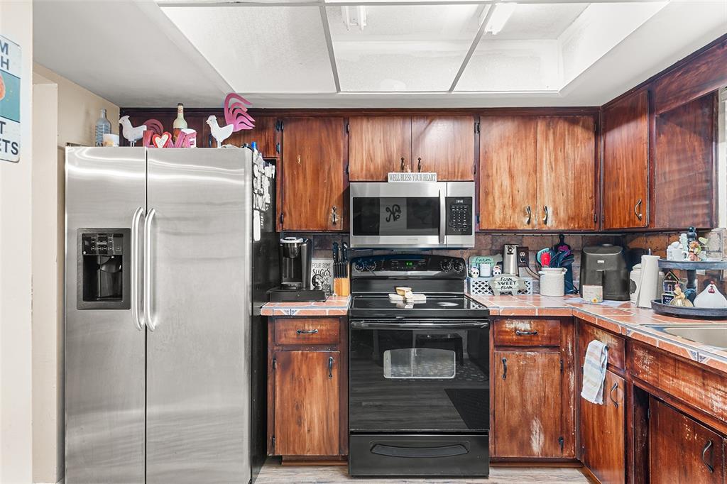 2282 Firestone Place Winter Haven, FL 33884 - Photo 8 of 34 a kitchen with stainless steel appliances granite countertop a refrigerator and a stove top oven