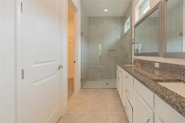 a bathroom with a granite countertop sink a mirror and a shower