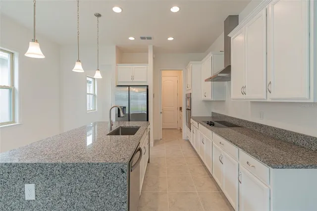 a large kitchen with stainless steel appliances granite countertop a stove and a sink