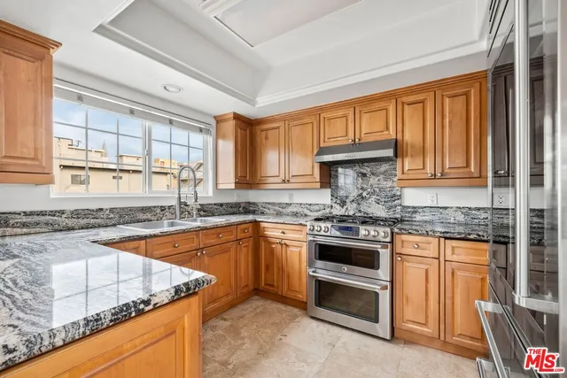 a kitchen with stainless steel appliances granite countertop a stove sink and cabinets