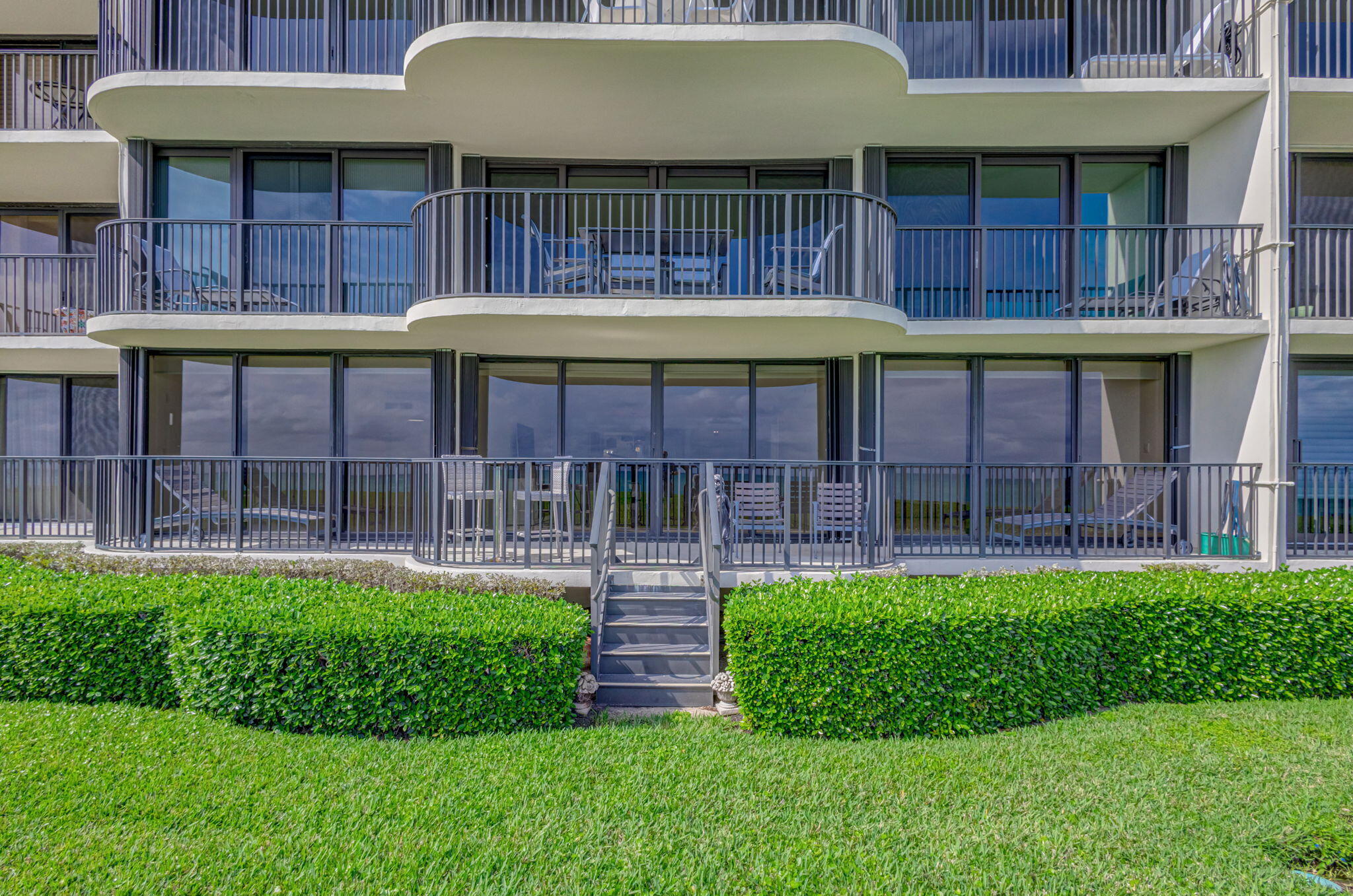 400 South Beach Road, Unit 103 Tequesta, FL 33469 - Photo 30 of 61 a front view of a house with a garden and plants