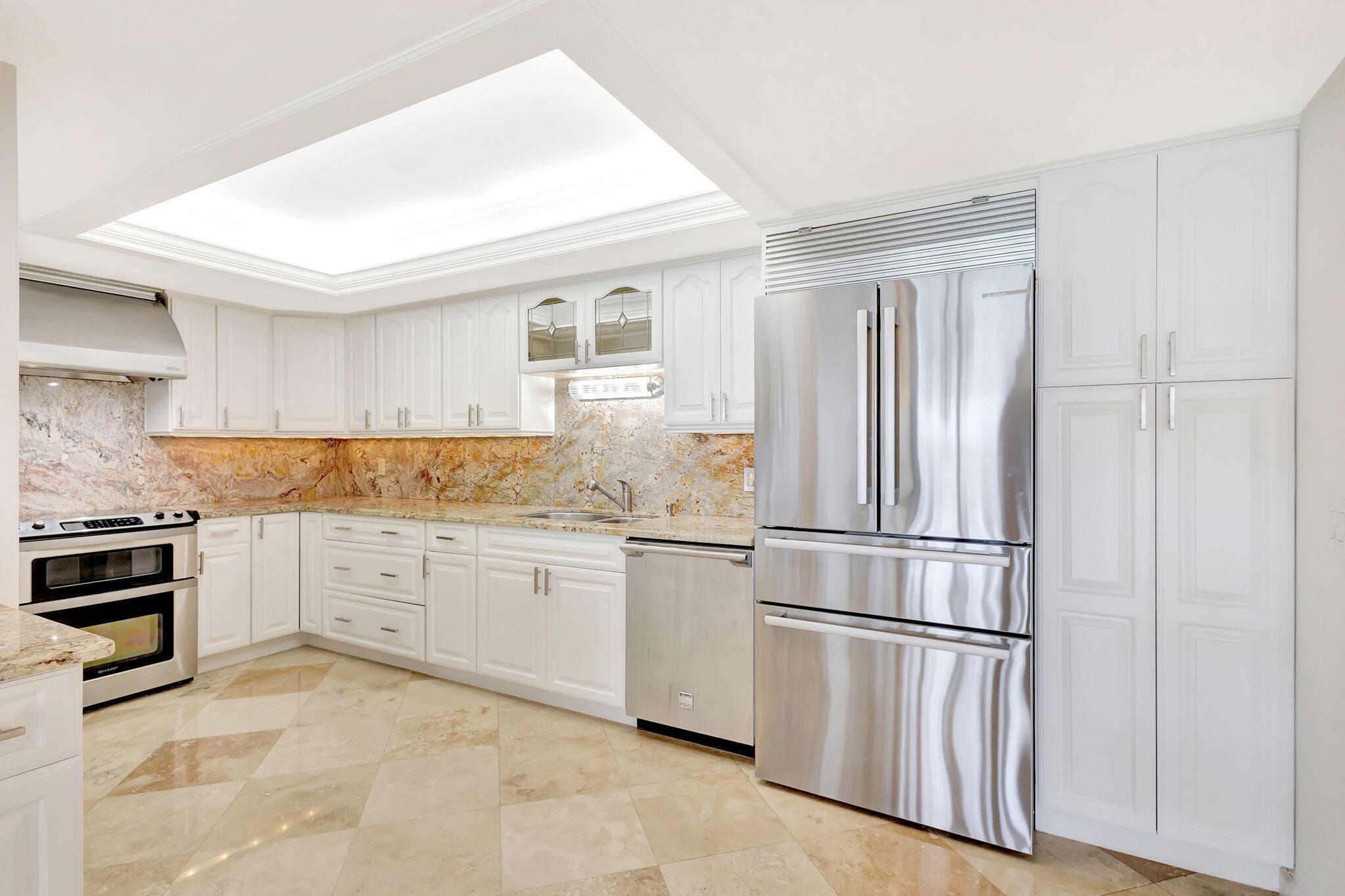 400 South Beach Road, Unit 103 Tequesta, FL 33469 - Photo 9 of 61 a kitchen with granite countertop stainless steel appliances and white cabinets